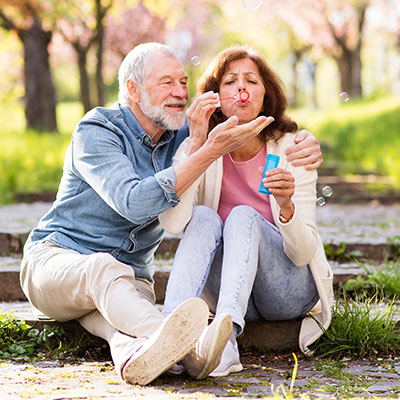 Elderly couple blowing bubbles