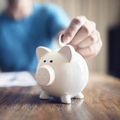 Person placing coin into piggy bank