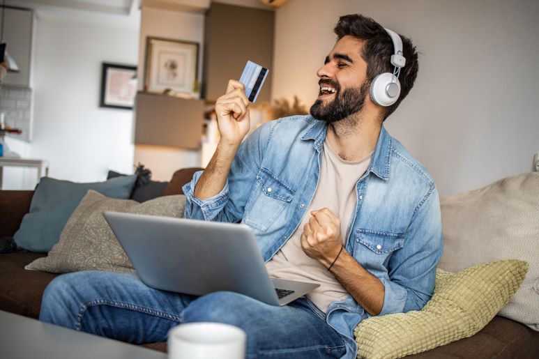 Man wearing headphones and holding credit card