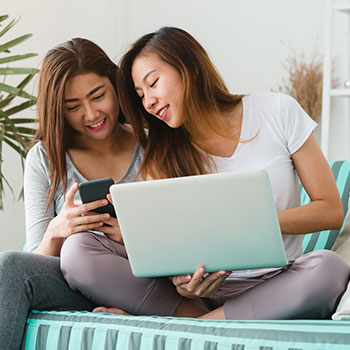 Young people on a laptop and a phone